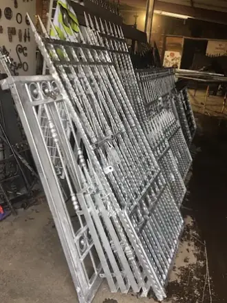 Silver metal gate frames stacked upright in the workshop