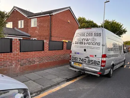 The NW Gates and Fencing van parked beside a brick wall with black infill panels